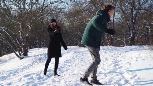 Couple heureux s'amusant dans la forêt d'hiver