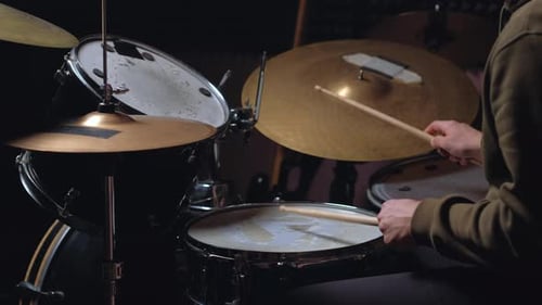 Drummer Playing Black Drum Set in Dark Studio