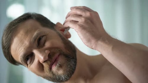 Man Cleaning Ear With Cotton Swab Close Up