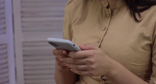 Woman's Hands Using Mobile Phone Indoors Close Up