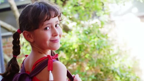 Portrait of happy schoolgirl standing in campus at school