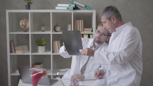 Two Male Doctors Checking X-ray in the Office of Modern Clinic. Concept of Medicine, Health Care and