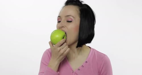 Woman Biting Into a Fresh Green Apple