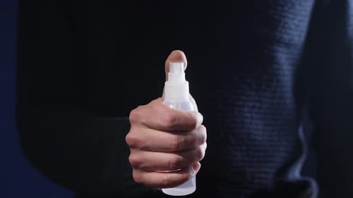 Hand Sprays Bottle Releasing Mist, Close Up Shot