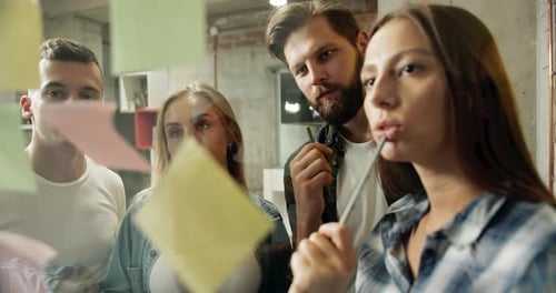 Team Brainstorming on Sticky Notes in Modern Office