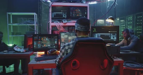Three People Working at Computers in Server Room