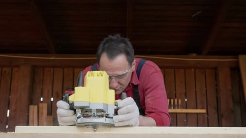 Woodworker Cutting Wooden Beam with Milling Machine in Diy Carpentry Workshop