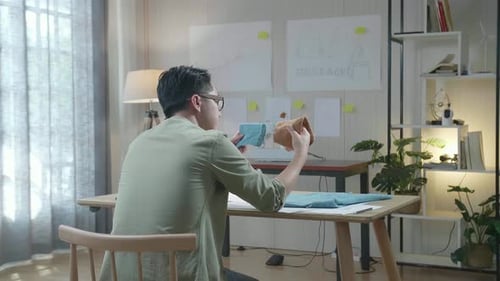 Vista posterior de un diseñador de bolsos de hombre con diseño de bonos mirando la tela en las manos