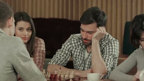 Jovens jogando xadrez com amigos
