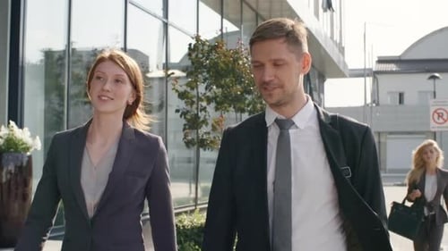 Colleagues Talking while Walking to Work Together