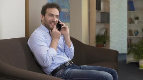 Man Talking on Mobile Phone on Couch at Home