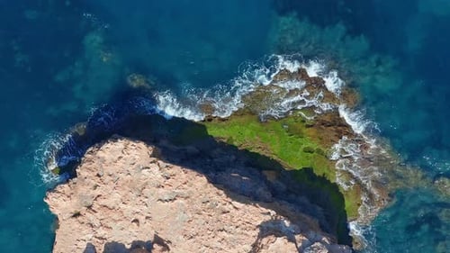 Aerial View. Ocean with Waves and Rocky Cliff.