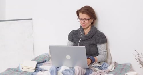 Woman Using Laptop Indoors With Books and Lavender