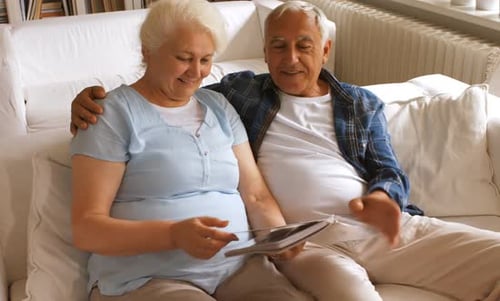 Senior Couple Looking at Photo Album on Sofa