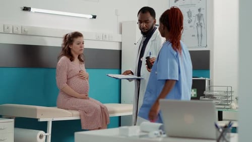 Pregnant Woman Talking to Doctor in Hospital Room