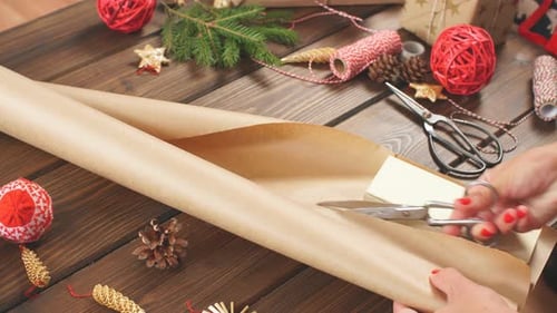 Woman Cuts Christmas Gift Wrap on Table