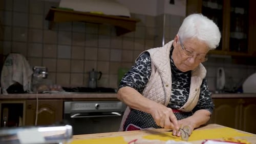 Senior Adult Cutting Dough in Kitchen