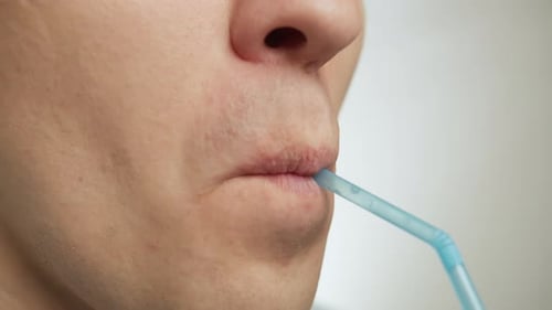 Close Up of Mouth Using Blue Straw