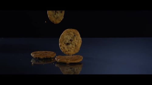 Cookies Falling onto Dark Reflective Surface