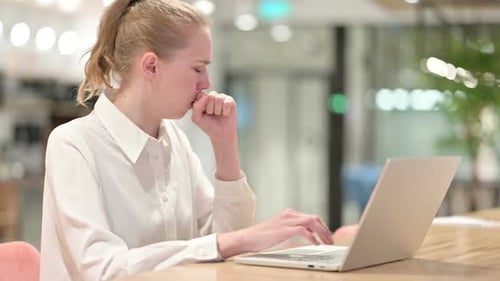 Ill Woman Coughing While Working on Laptop