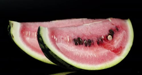 Sliced Watermelon Wedges on Black Reflective Background