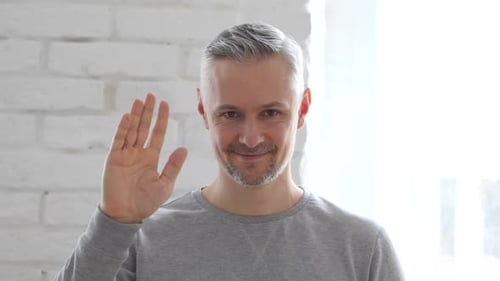 Hallo, Mann mittleren Alters winkt mit der Hand