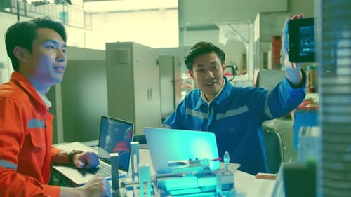 Engineers Collaborate at Table in Industrial Workplace