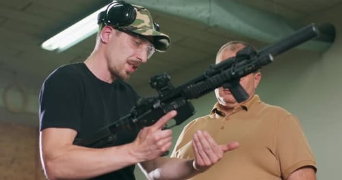 Men Inspecting Rifle Inside Shooting Range