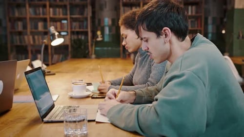 Students Studying Together in Library with Laptops