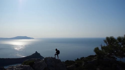 Woman with a Backpack Admires a Beautiful Wide View of the Sea Under the Sun and Waves Hands