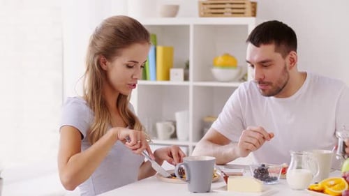 Young Couple Eating Breakfast Together at Table