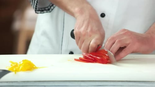 Chef Slices Red Pepper on Cutting Board