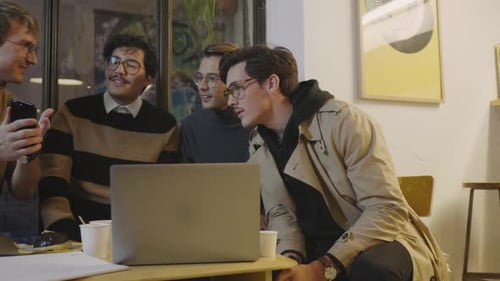 Team Working Together at a Laptop in Urban Cafe