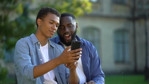 Friends Viewing Smartphone Outside Building