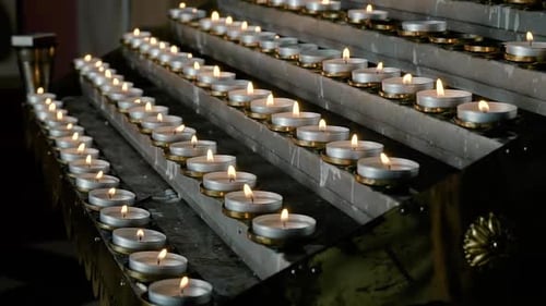 Rows of Burning Lit Candles in Catholic Cathedral