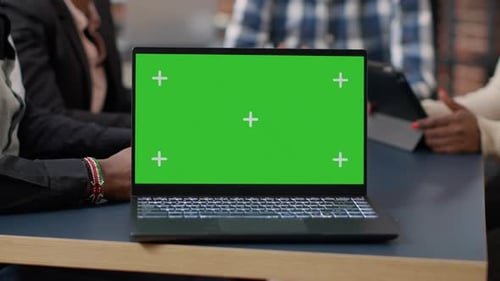 Laptop Display with Green Screen Background on Office Desk