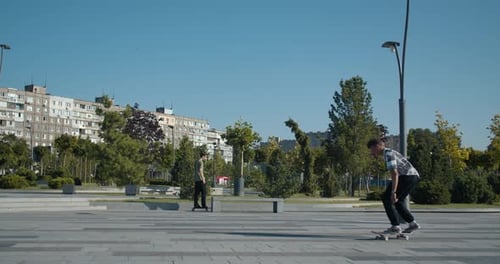 Two Teenagers Are Skateboarding at the Skatepark in the Morning,