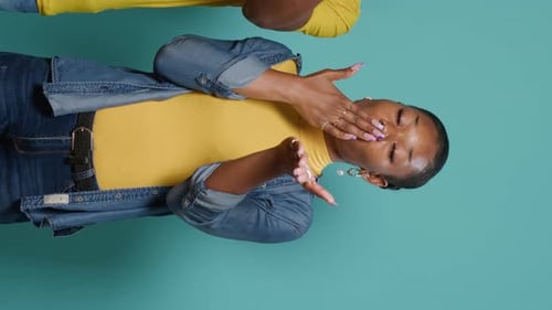 Vertical Video Man and Woman Blowing Air Kisses with Hands and Lips on Studio Camera
