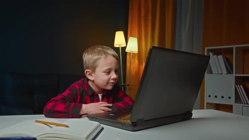 Child Waving at Laptop in an Indoor Setting