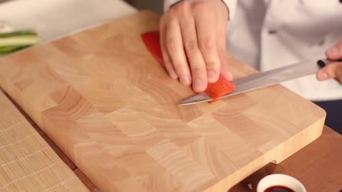Man Hands of Chef Cut Up Piece of Fish By Cutting Knife