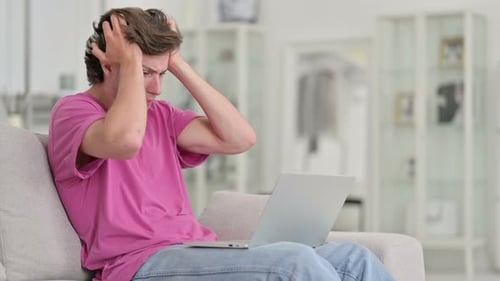 Frustrated Man Using Laptop in Bright Home