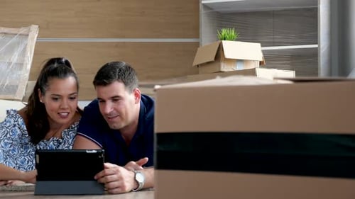 Young Couple Use Tablet in New Home