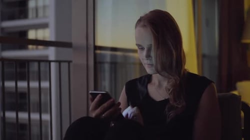Woman Uses Smartphone in Dark Apartment at Night