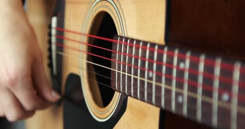 Tocando una guitarra de cerca en cámara superlenta a 300 fps