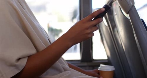 Using Phone on Public Transportation While Holding Coffee