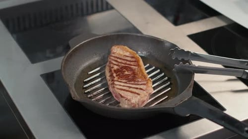 Ribeye Steak Sizzling on Griddle in Kitchen