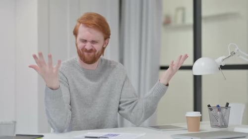 Frustrated Redhead Man at Desk in Office