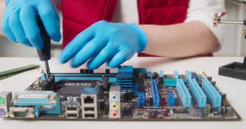 Closeup of Repairman Hands in Protective Gloves Fixing Microchip for Gadget
