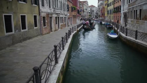 Góndola que lleva turistas a lo largo de una bonita calle estrecha en Venecia, viaje a Italia