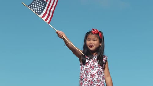 Child Waving American Flag on Fourth of July